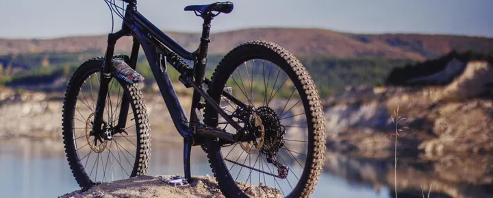 A bike on a rock above a quarry lake