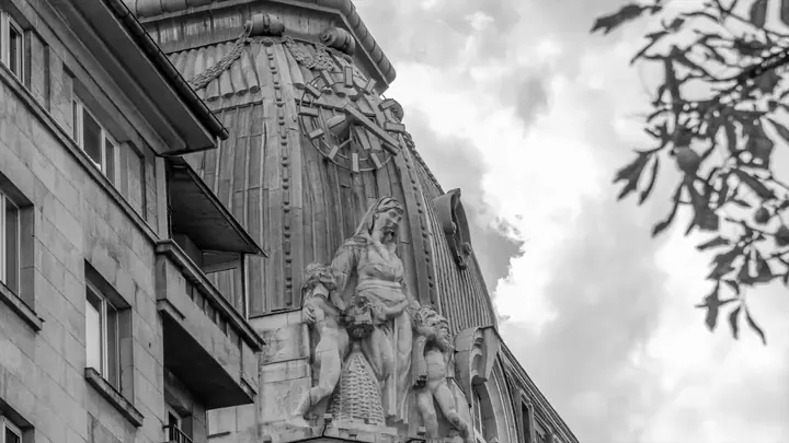 A statue on a facade against cloud